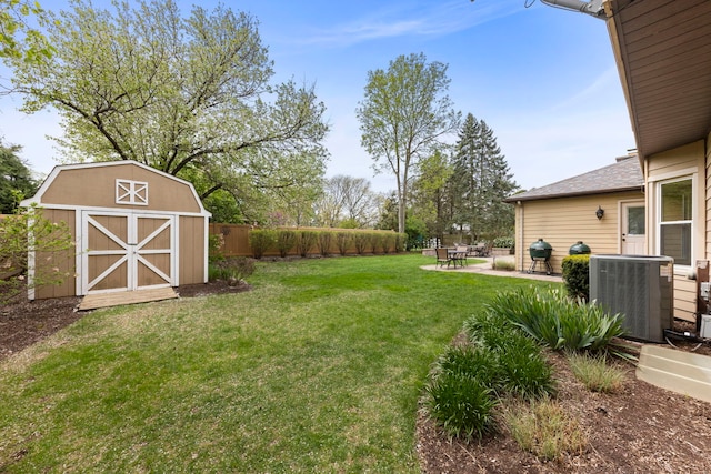 view of yard featuring a storage shed, central air condition unit, an outdoor structure, a fenced backyard, and a patio