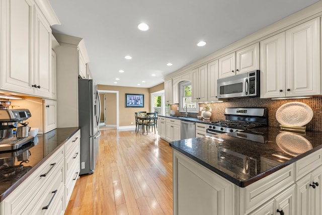 kitchen featuring a sink, appliances with stainless steel finishes, tasteful backsplash, and baseboards