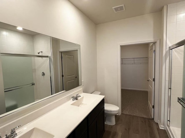 full bath with wood finished floors, visible vents, a stall shower, and a sink