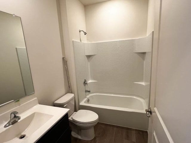 bathroom with toilet, vanity, wood finished floors, and tub / shower combination