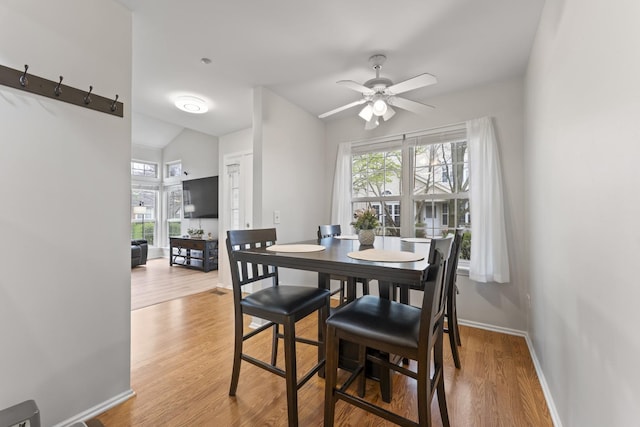 dining space featuring baseboards, ceiling fan, wood finished floors, and lofted ceiling