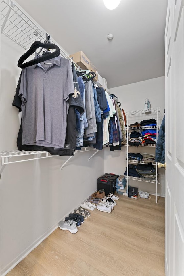 walk in closet with wood finished floors