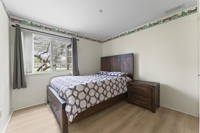 bedroom with baseboards, light wood-type flooring, and visible vents
