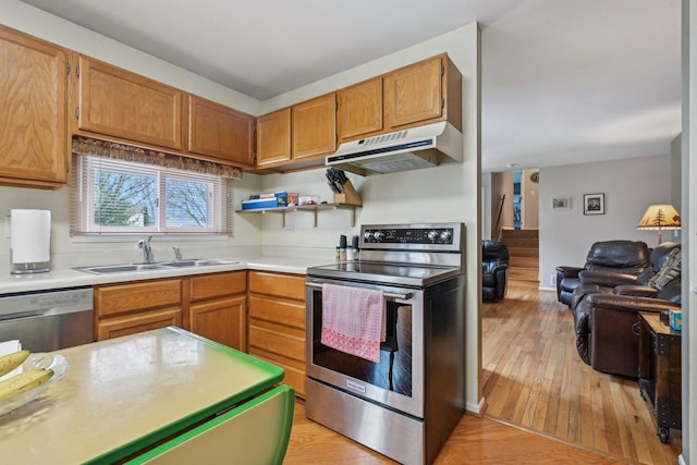 kitchen featuring a sink, light countertops, light wood finished floors, appliances with stainless steel finishes, and under cabinet range hood