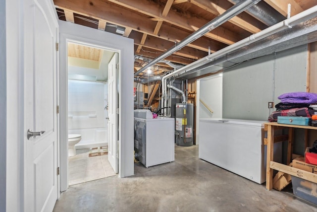 unfinished basement with refrigerator, water heater, and independent washer and dryer