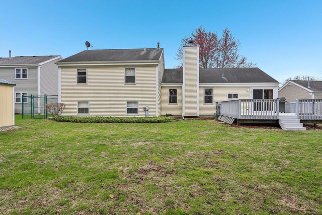 back of property featuring a chimney, fence, and a yard