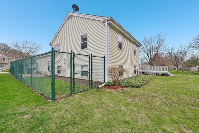 view of side of property featuring a gate, a yard, fence, and a deck