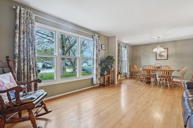 dining area with hardwood / wood-style flooring, baseboards, and a notable chandelier