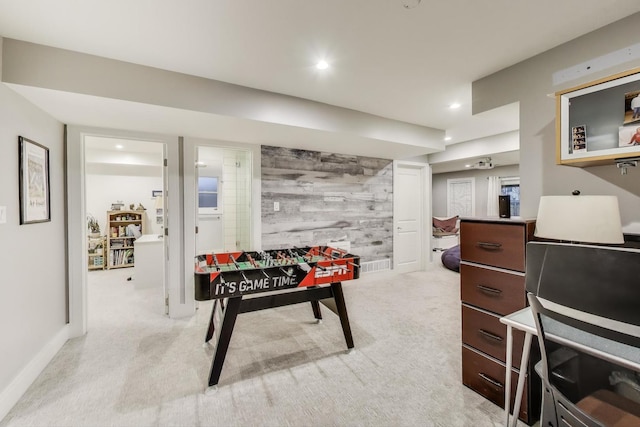 recreation room with an accent wall, light carpet, recessed lighting, baseboards, and wooden walls