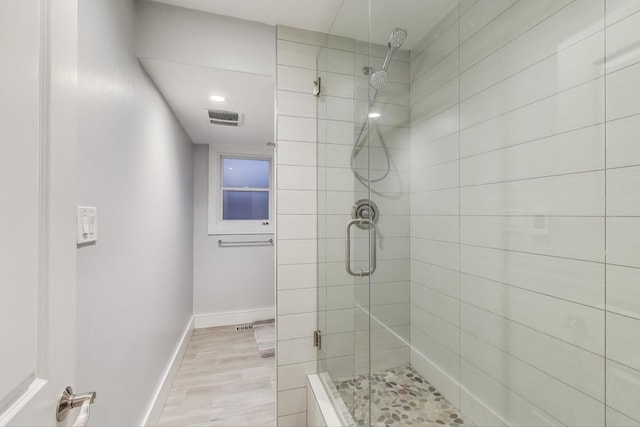 bathroom featuring a stall shower, wood finished floors, and baseboards