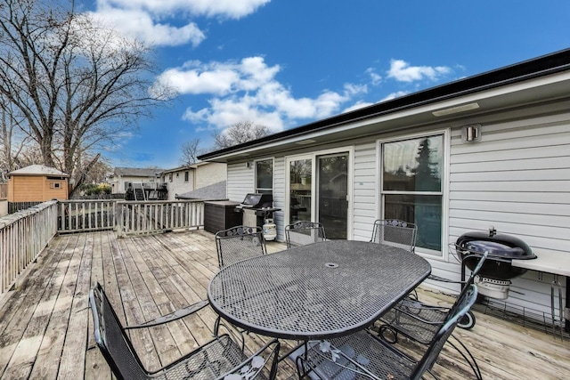 wooden terrace featuring area for grilling and outdoor dining space