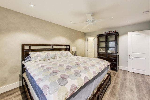 bedroom featuring baseboards, wood finished floors, a ceiling fan, and recessed lighting
