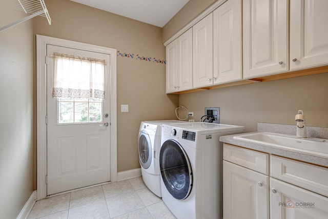 laundry area with cabinet space, washer and dryer, a sink, baseboards, and light tile patterned floors
