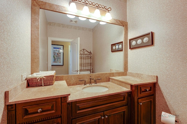 bathroom with toilet, wallpapered walls, visible vents, and vanity