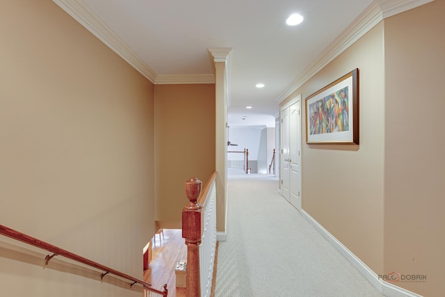 hallway featuring crown molding, carpet floors, baseboards, recessed lighting, and an upstairs landing
