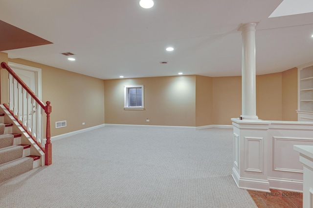finished basement with visible vents, baseboards, and stairway
