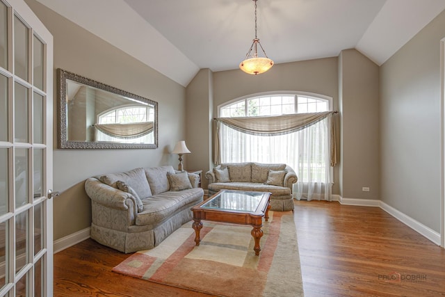 living room featuring baseboards, lofted ceiling, and wood finished floors