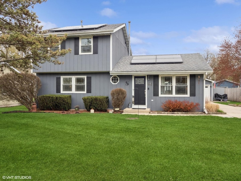 5216 Palm St, Mchenry, IL 60051 - traditional home featuring a shingled roof, a front lawn, solar panels, driveway, and a garage