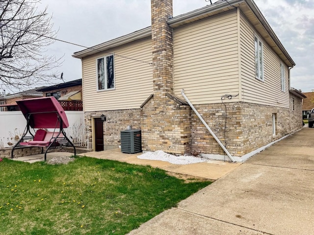 8129 45th Pl, Lyons, IL 60534 - rear view of house featuring a chimney, brick siding, fence, and cooling unit
