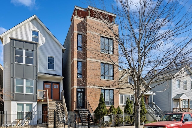 view of front of home featuring brick siding and a fenced front yard