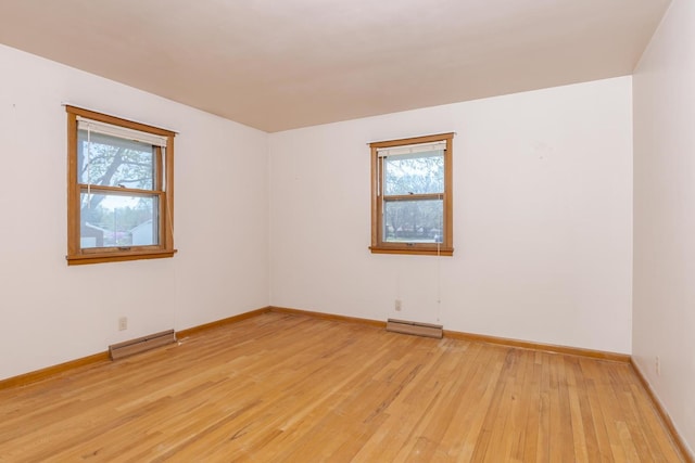 empty room with visible vents, baseboards, light wood-style flooring, and plenty of natural light