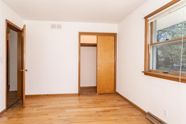 unfurnished bedroom with light wood-style floors, visible vents, and baseboards