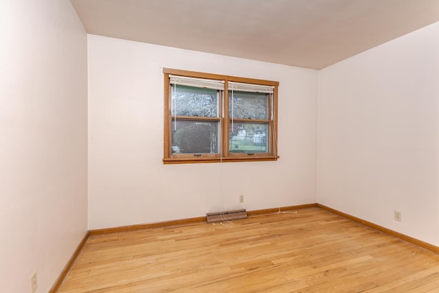 unfurnished room with visible vents, light wood-style flooring, and baseboards