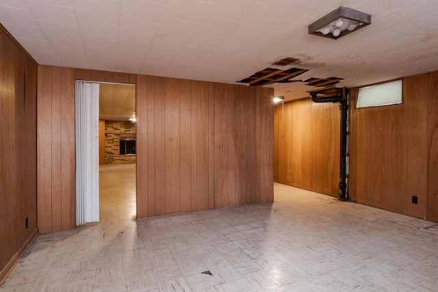finished below grade area with wooden walls and a brick fireplace