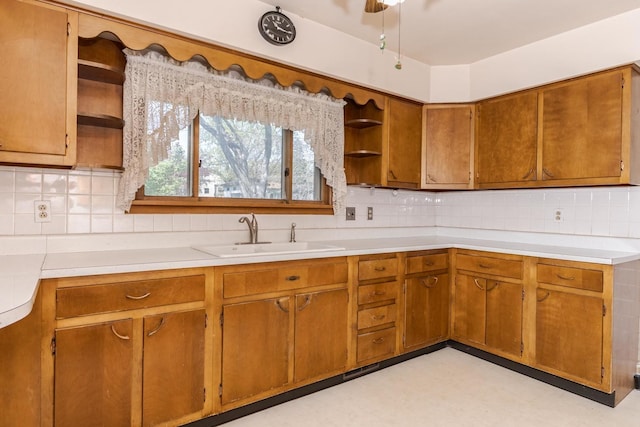 kitchen featuring backsplash, light countertops, open shelves, and a sink