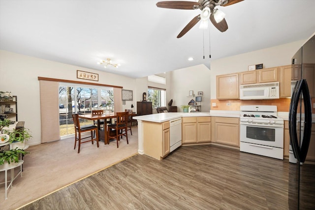 kitchen with light countertops, wood finished floors, light brown cabinets, white appliances, and a peninsula