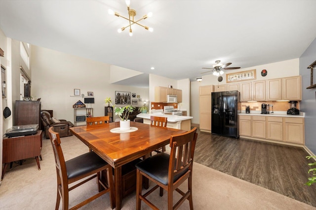dining area with dark wood-style floors and ceiling fan with notable chandelier