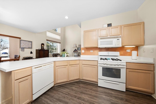 kitchen featuring light brown cabinets, a peninsula, white appliances, and light countertops