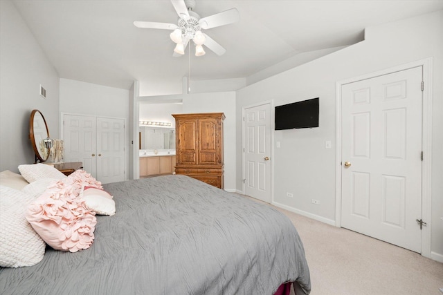 bedroom with baseboards, visible vents, light colored carpet, a ceiling fan, and ensuite bath