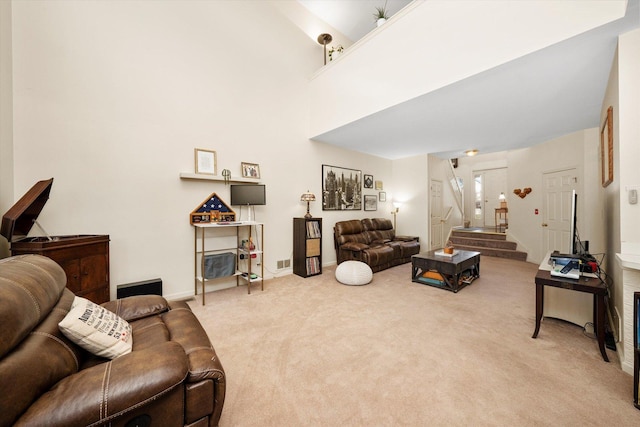 living room featuring light carpet, stairs, and baseboards