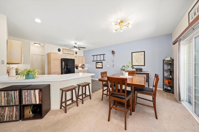 dining room with a ceiling fan, light colored carpet, and a healthy amount of sunlight