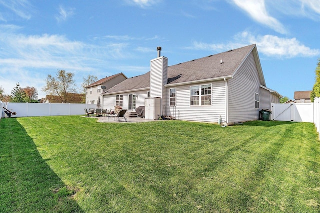 1035 Heritage Dr, Diamond, IL 60416 - rear view of house featuring a chimney, a lawn, a gate, a patio area, and a fenced backyard