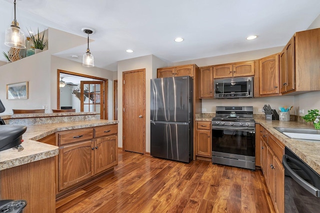 1035 Heritage Dr, Diamond, IL 60416 - kitchen with dark wood-style flooring, appliances with stainless steel finishes, hanging light fixtures, a sink, and light countertops