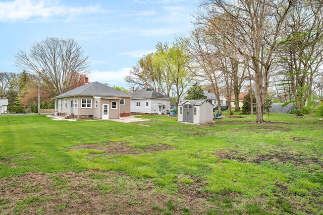 112 W 1st St, Streator, IL 61364 - back of property featuring a patio, an outbuilding, a yard, a storage shed, and a chimney
