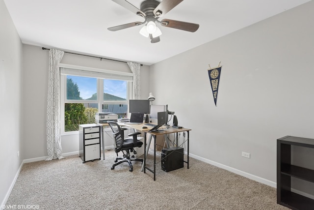 carpeted office featuring baseboards and ceiling fan