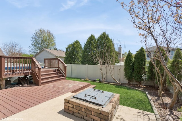 deck featuring a yard, a patio, and a fenced backyard