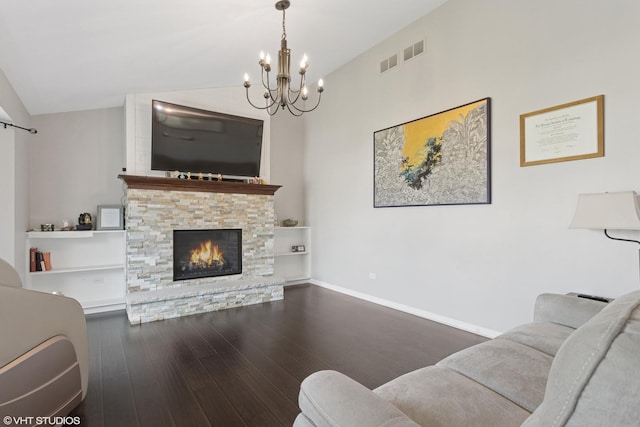 living area featuring a fireplace, a notable chandelier, lofted ceiling, visible vents, and wood finished floors