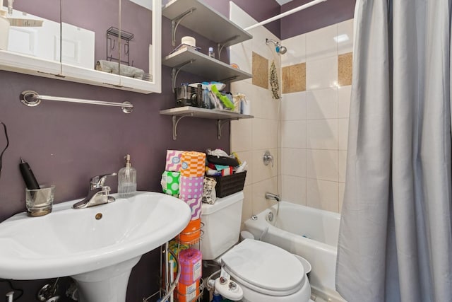 full bathroom featuring toilet, a sink, and shower / bath combination with curtain