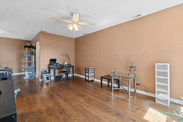 office with wood finished floors, visible vents, a ceiling fan, and baseboards