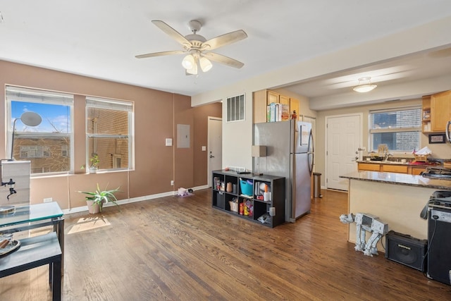 interior space featuring wood finished floors, visible vents, dishwasher, dark stone counters, and ceiling fan