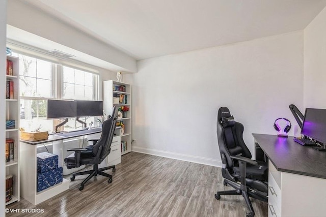 office space with visible vents, baseboards, and wood finished floors