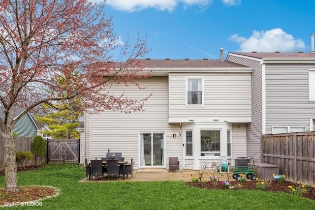 rear view of property featuring a fenced backyard, a gate, central air condition unit, a patio area, and a lawn
