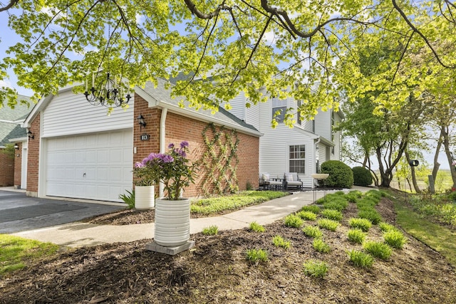 113 Welwyn St Unit 0, Lake Bluff, IL 60044 - view of front facade with brick siding, a garage, and driveway