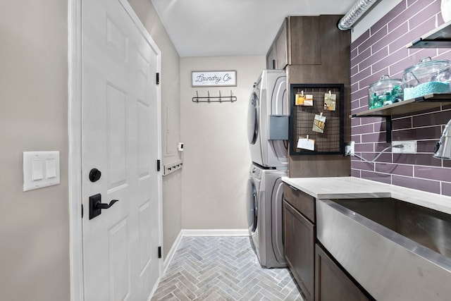 113 Welwyn St Unit 0, Lake Bluff, IL 60044 - clothes washing area featuring cabinet space, stacked washing machine and dryer, brick patterned flooring, and baseboards