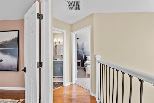 113 Welwyn St Unit 0, Lake Bluff, IL 60044 - hallway with light wood-style floors, a sink, baseboards, and an upstairs landing