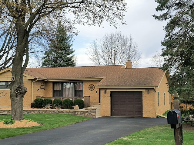 ranch-style home with a chimney, a garage, brick siding, aphalt driveway, and a shingled roof